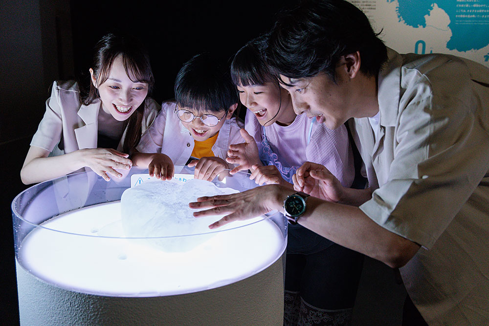 南極の氷の展示を見ている家族
